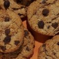Cookies de chocolate sobre uma superfície laranja.
