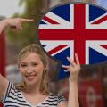 mulher segurando um balão de conversa estampado com a bandeira da Inglaterra