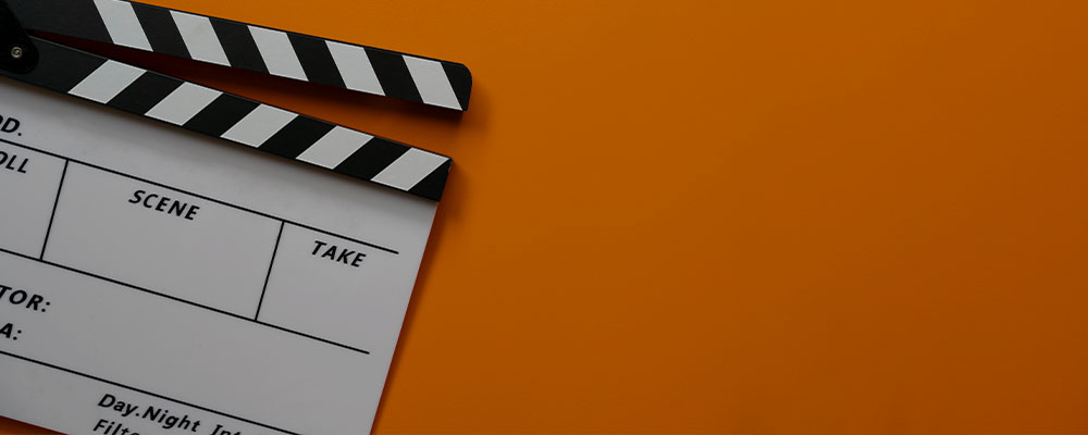 claquete, um símbolo de gravação de vídeos, sobre um fundo laranja