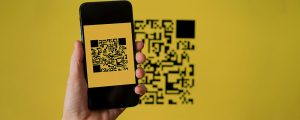 celular apontando para um QR Code com um fundo amarelo