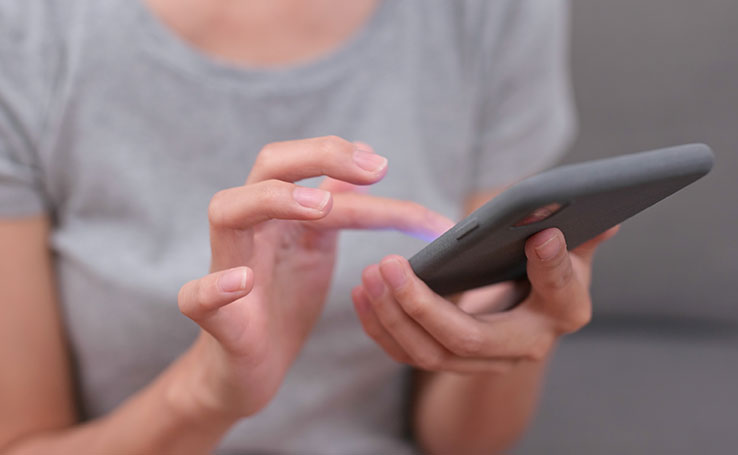 mãos femininas mexendo no celular