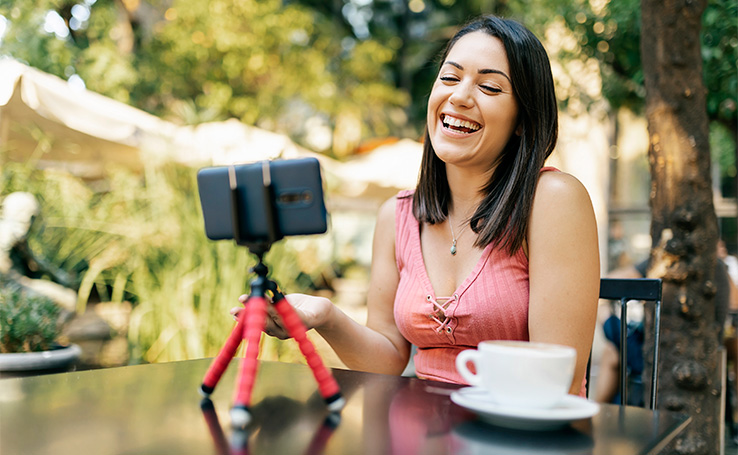 mulher-tomando-cafe-ao-ar-livre-gravando-video-com-celular