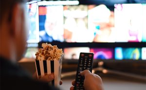 homem-segurando-controle-da-televisao-e-pipoca