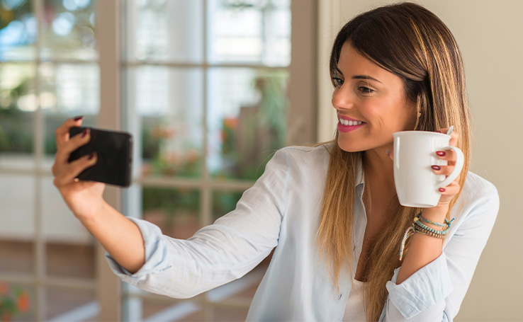 mulher tirando selfie tomando café