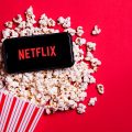 celular com Netflix aberto em cima de pipocas
