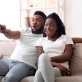 casal sentado no sofá assistindo lançamentos da Netflix de julho de 2022