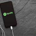 celular com fone de ouvido conectado executando o Spotify