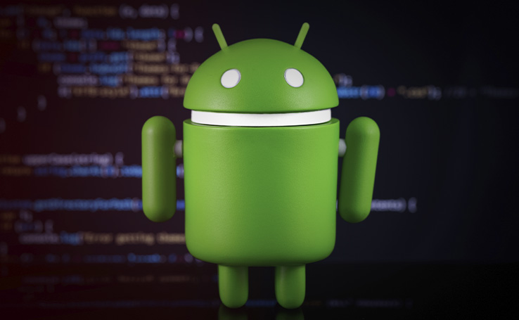 bonequinho do Android em frente à uma tela cheia de códigos