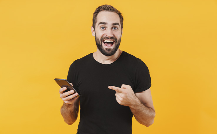 homem sorrindo e apontando para o celular