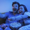 casal com balde de pipoca no colo assistindo os lançamentos da Netflix