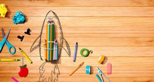 foguete feito com materiais escolares em cima de uma mesa de madeira, simbolizando o estímulo da criatividade