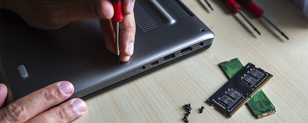 homem removendo a tampa de um notebook para instalar um SSD