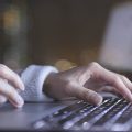 mãos digitando no teclado de um notebook