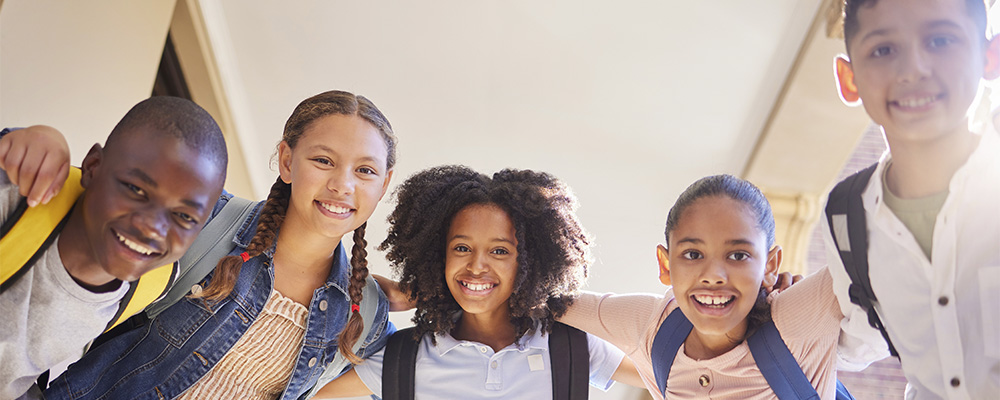 crianças abraçadas na escola representando o desenvolvimento de competências socioemocionais