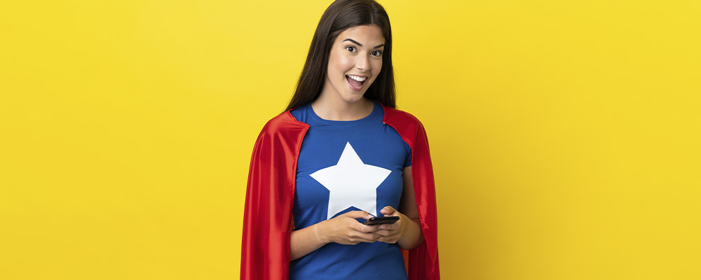 garota usando roupa de super herói enquanto usa seu smartphone fazendo alusão aos super apps