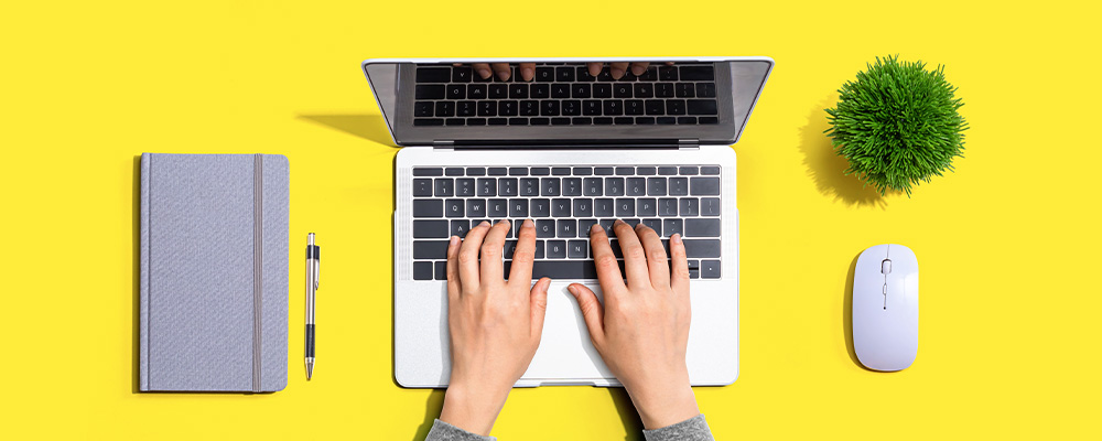 mãos em cima de um teclado de notebook procurando emprego na internet