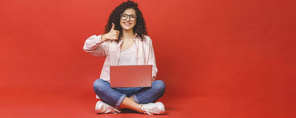 garota usando notebook em um fundo vermelho