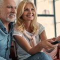 casal abraçados no sofá assistindo os lançamentos da Netflix