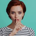 mulher com o dedo indicador sobre os lábions, indicando o silêncio das notificações no Instagram