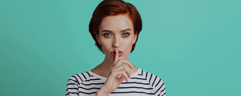 mulher com o dedo indicador sobre os lábions, indicando o silêncio das notificações no Instagram