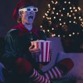 homem vestido de duende do Papai Noel assistindo filmes de Natal