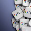 logos do Google Pay em 3D espalhados em uma superfície cinza