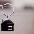 chave na fechadura de uma porta adornada com um chaveiro em formato de casa, fazendo alusão a casas de aluguel para férias, que podem ser encontradas no Booking