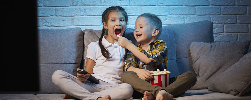 crianças no sofá assistindo os lançamentos da Netflix de junho de 2023