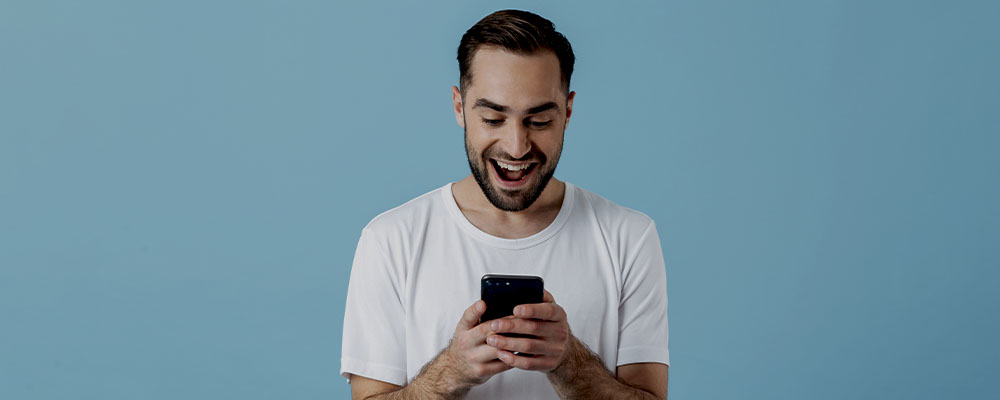 homem feliz usando o YouTube em segundo plano no celular