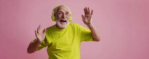 idoso muito feliz ouvindo música pelo Spotify com headphones coloridos