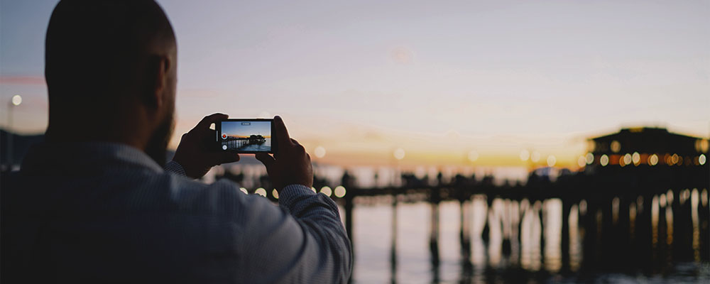 homem tirando foto de uma paisagem com o celular