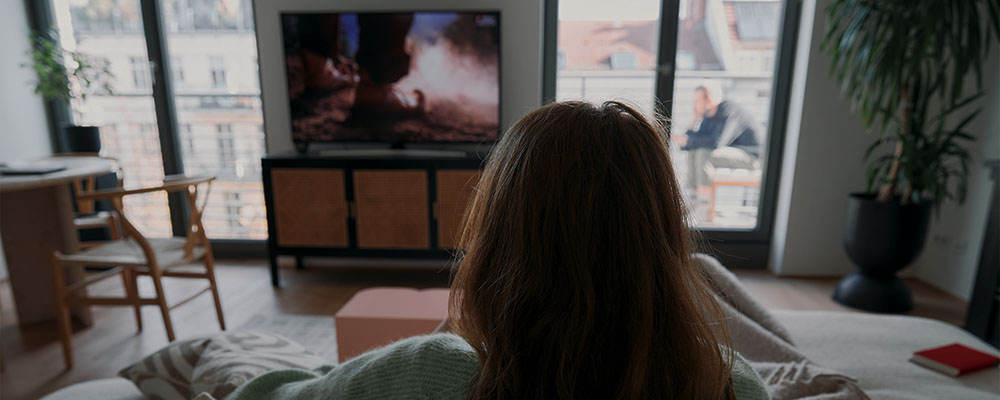 mulher assistindo vídeos do Facebook na TV