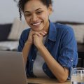 mulher sorrindo enquanto usa um dos navegadores Opera ou Chrome em um notebook