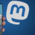 celular com o início do Mastodon aberto e o logo da rede ao fundo