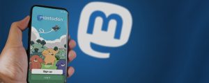 celular com o início do Mastodon aberto e o logo da rede ao fundo