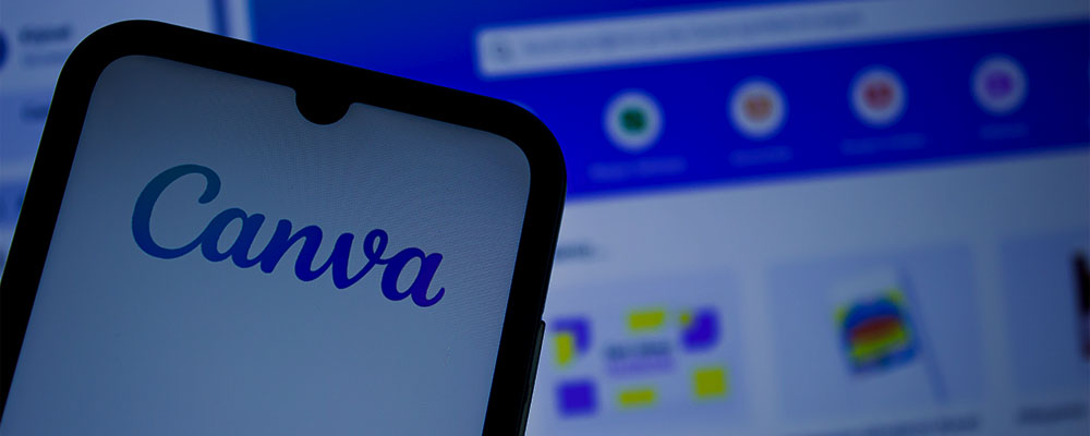 celular com o app do Canva aberto e um notebook ao fundo com a versão web do Canva aberta