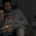 casal assistindo filme de terror abraçados no sofá