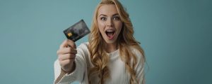 mulher supresa segurando um cartão de crédito