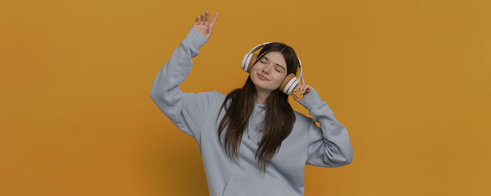 garota dançando enquanto ouve música em headphones