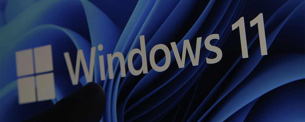 dedo encostando no logo do Windows 11 em uma tela de computador