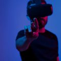 homem usando óculos de realidade virtual tocando em algo que pode ser visto no Metaverso