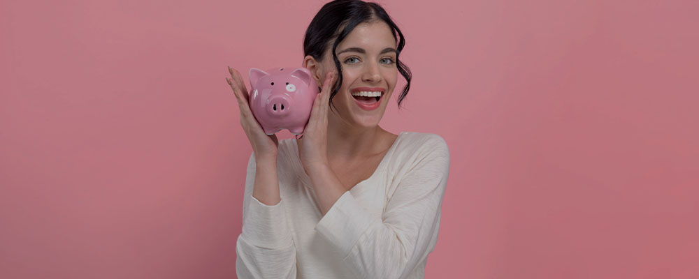 Mulher segurando um confrinho em formato de porco, simbolizando as ecnonmias ao comprar online.