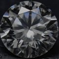 Diamante lapidado sobre uma superfície preta.