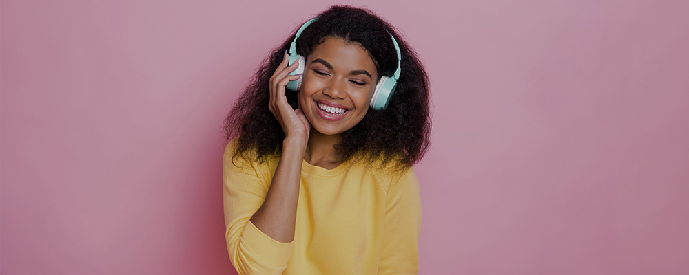 Mulher ouvindo música em fones de ouvido bluetooth.