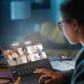 Mulher usando um notebook Positivo Vision i15 para trabalhar em seu home office em um ambiente de baixa luminosidade.