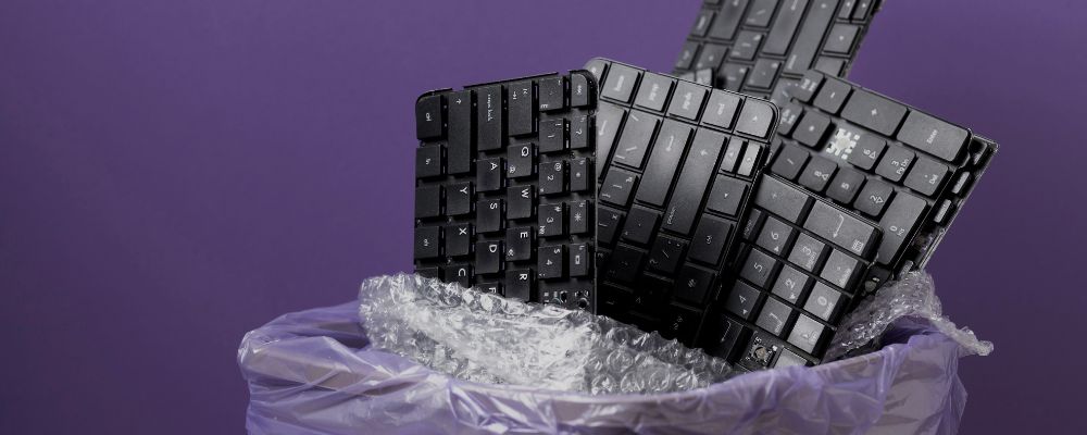 Vários teclados em uma lixeira.