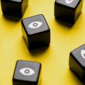 Cubos pretos com olhos desenhados representando a vulnerabilidade dos nossos dados pessoais na internet.