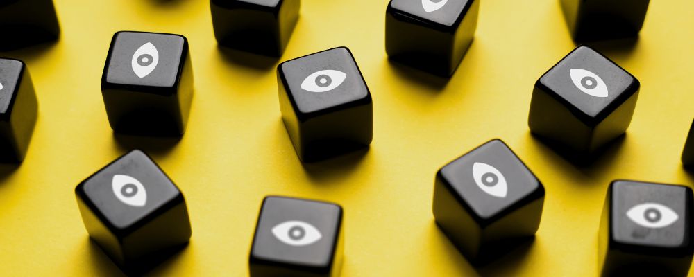 Cubos pretos com olhos desenhados representando a vulnerabilidade dos nossos dados pessoais na internet.