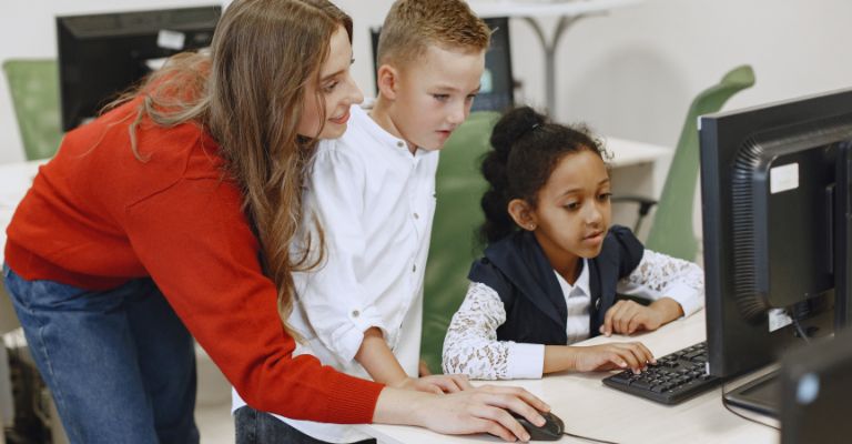 Professora promovendo a inclusão digital de seus alunos.