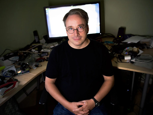 Linus Torvalds, criador do Linux, sentado em uma cadeira em frente a um computador.